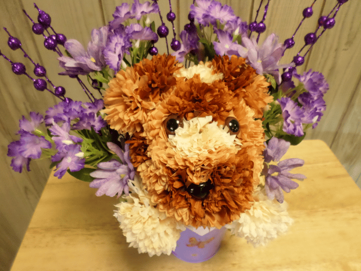 A fun puppy bouquet made out of silk flowers