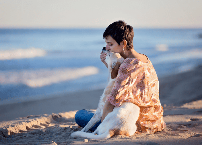 Woman with her dog on the beach