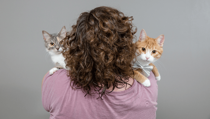 Woman holding two cats