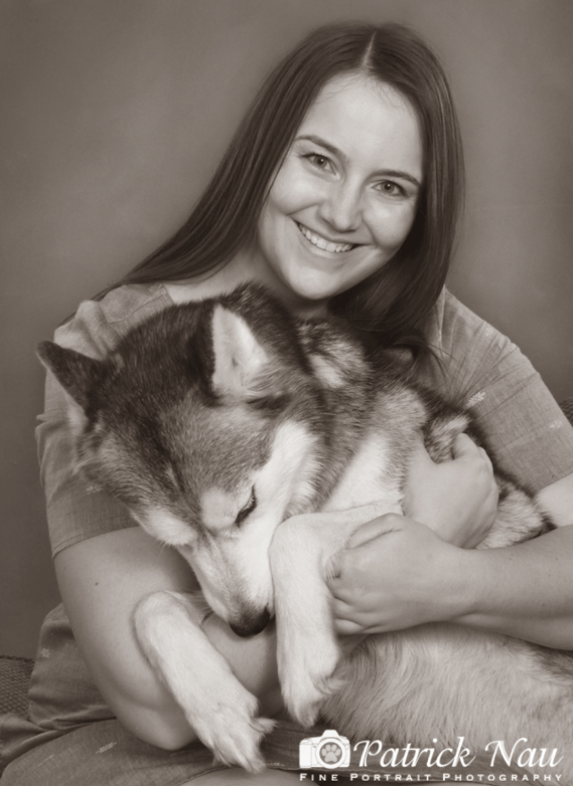 A portrait of a woman hugging her dog