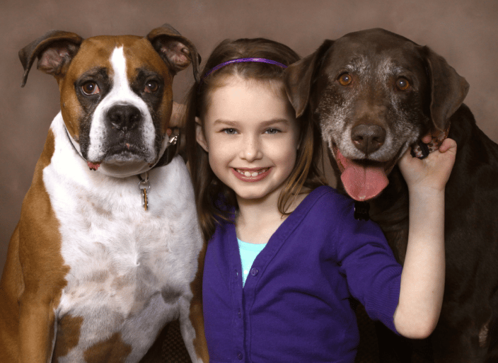 A portrait of  a girl and her two dogs.