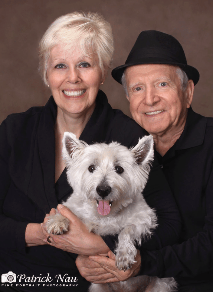 A portrait of a couple with their dog