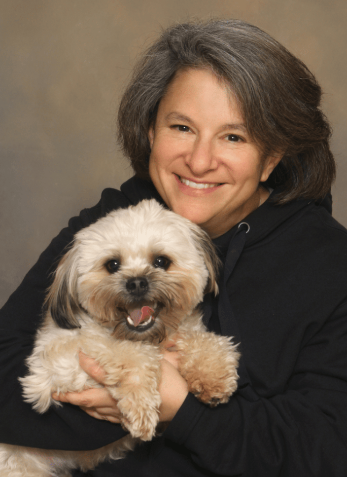 A portrait of a woman hugging her dog