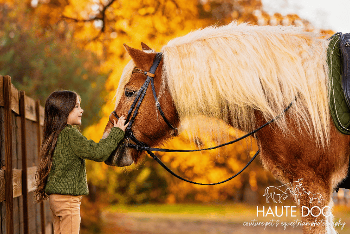 Girl pats her pony on the face
