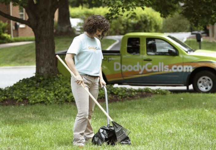 A woman scooping dog waste