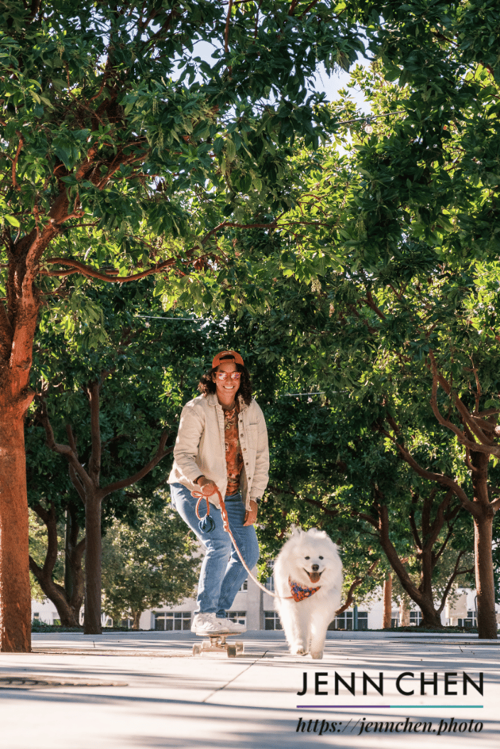 skateboarding parent and their samoyed in the city